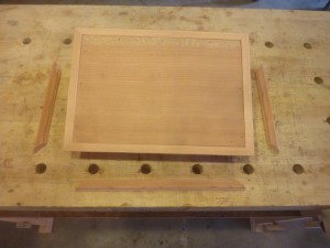 This is the Tantalus Lid with the top side edge trim nailed on, those bits to the side are the top trim that will cloak the seam between the cherry top and the side trim. 